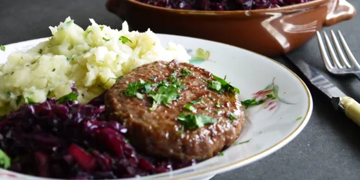 Bommelburger met knolselderijpuree en geroerbakte rode kool