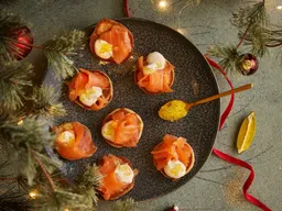 Blini's met gerookte zalm, zure room en citruskaviaar