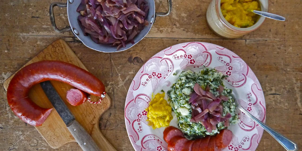 Boerenkool-koolraapstamppot met een rookworstje en uienrelish